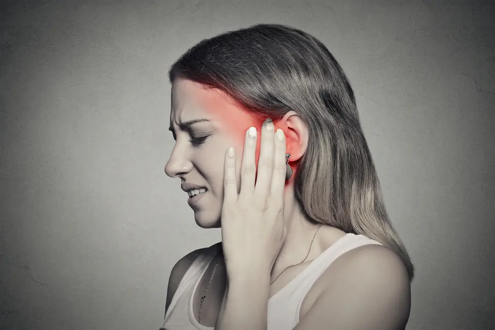 Female having ear pain touching her painful head could be Tinnitus
